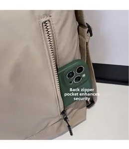 Detail of a beige nylon crossbody bag featuring a vertical anti-theft back zipper pocket
