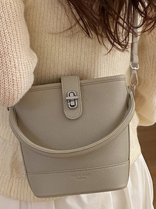 Fashionable beige bucket bag with lychee pattern leather and elegant metal lock closure