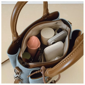 Top view of blue and brown handbag showing interior compartments with daily essentials