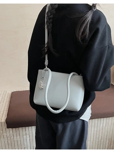 Detailed back view of a light sage green soft leather bucket bag worn by a model