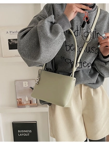 Detailed view of light green minimalist shoulder bag with silver chain accessory