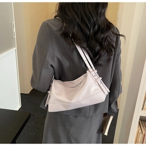 Detail showing the glossy finish and silver buckles of the lavender pink shoulder bag