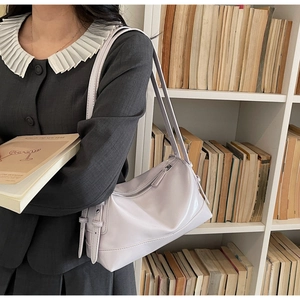 Detail of lavender faux leather shoulder bag showing the side buckle and smooth texture