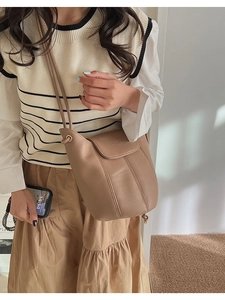 Detail view of khaki pebbled leather bucket bag styled with Japanese minimalist outfit
