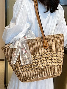 Large straw woven tote bag with floral lace bow and brown leather straps for beach