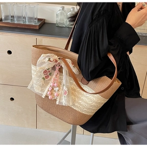 Detailaufnahme der Strohtasche mit Rosenstickerei, Spitze und Perlenanhänger-Detail