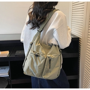 Detail view of khaki nylon multi-pocket crossbody bag with adjustable wide strap for women