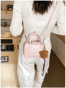 Vue détaillée d'une femme portant un mini sac Boston rose avec un charmant ours peluche