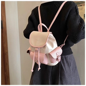 Close-up of pink and beige leather backpack with drawstring closure and buckle details