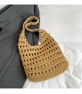 Close-up of khaki crochet straw bag with hollow grid mesh texture on grey blazer