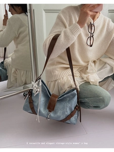Macro detail of vintage blue crossbody bag with silver star charm and brown leather strap