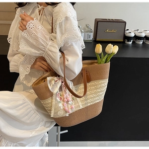 Detailaufnahme der Stroh-Tasche mit beiger Spitze und rosa Perlen-Blumenanhänger