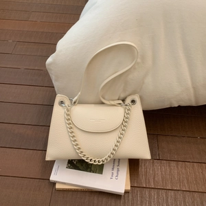 Detailed macro view of cream leather handbag with lychee texture and thick chain strap
