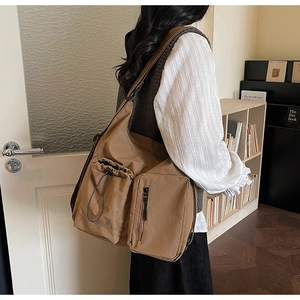 Detail of vintage brown canvas messenger bag with multi-pocket design and drawstring pocket