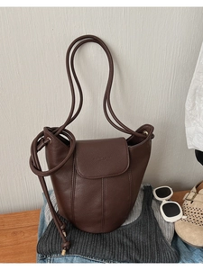 Close-up of deep brown lychee grain leather bucket bag with elegant stitching details