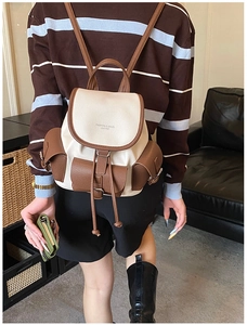 Detail of vintage beige leather backpack with drawstring closure and brown flap cover