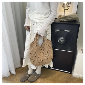 Gros plan sur le sac à bandoulière en corde de coton marron avec motif losanges ajourés