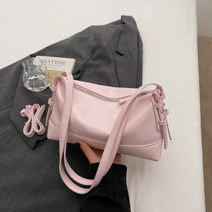 Pink soft leather underarm bag with adjustable strap on a grey blazer background