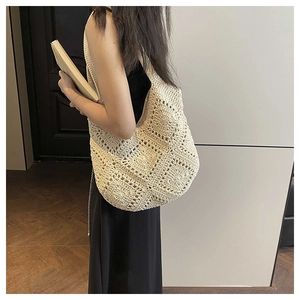 Détail d'un sac cabas en crochet beige avec motif tricoté géométrique porté à l'épaule