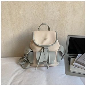Close-up of contrast beige and green faux leather backpack with drawstring and flap closure