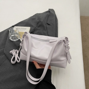 Detailed close-up of soft purple leather shoulder bag with silver zipper and strap buckle