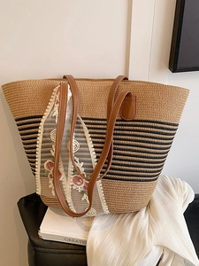 Large woven straw tote bag with black stripes and elegant floral lace ribbon detail