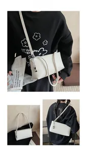 Detailed views of the creamy white rectangular baguette bag with chic silver metal charms
