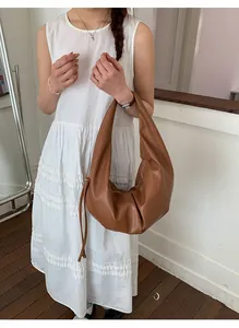 Detail of soft brown pleated hobo bag showing the rich matte texture and drawstring accents