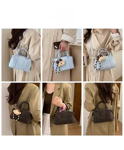 Detail view of retro Boston bags in blue and brown with plush bear charms and shoulder straps