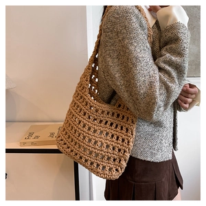 Detail view of caramel woven tote bag featuring a hollow mesh structure and soft cotton straps