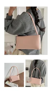 Detailed view of pink rectangular shoulder bag with silver peanut charm accessory