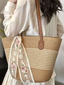 Large woven straw tote bag with brown stripes and floral silk scarf accessory
