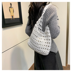 Detail of white crochet shoulder bag showing large mesh hollow texture on a female model