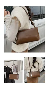 Detailed views of a dark brown vintage baguette bag with stylish silver heart charm