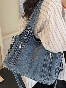 Retro denim shoulder bag in stone washed blue with multiple zipper pockets and wide strap