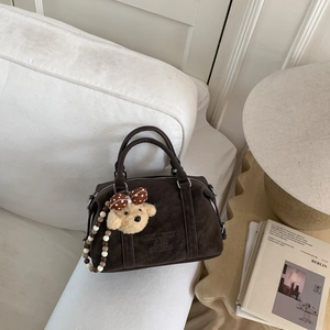 Detail of vintage Boston bag featuring 3D embossed text and cute teddy bear charm