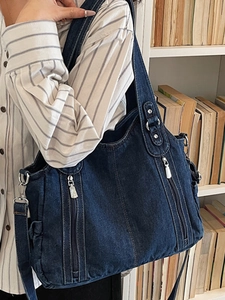 Chic dark blue washed denim shoulder bag with silver zippers and wide strap in casual style