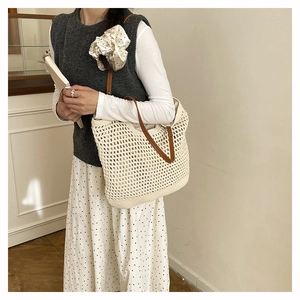 Detail of hand-woven hollow tote bag with premium brown leather shoulder straps
