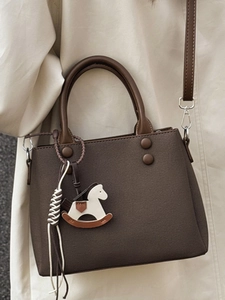 Brown minimalist tote bag with horse charm and top handles in textured faux leather