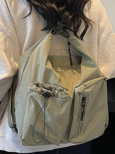 Minimalist sage green multi-pocket crossbody bag for women with drawstring detail