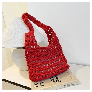 Detailed macro view of the red handmade hollow-out woven tote bag in a home setting