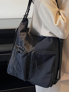 Minimalist black nylon crossbody bag with multi-pocket design and adjustable strap