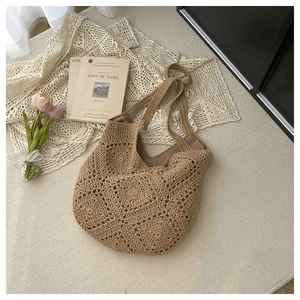 Détail du motif floral ajouré sur le sac à bandoulière tissé avec doublure marron