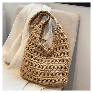 Detailed view of woven straw tote bag texture hanging on a chair with casual blazer