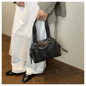 Detailed close-up of retro distressed leather Boston tote bag carried by a model