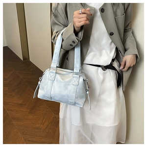 Minimalist light blue vintage pillow tote bag styled with casual grey suit for urban look