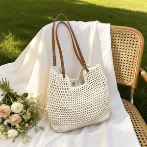 Detailed close-up of the white woven cotton texture and brown faux leather strap of the tote