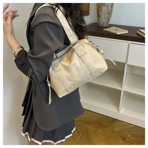 Detail view of cream vintage tote bag showing X-pattern stitching and metallic hardware