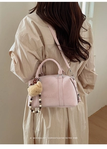 Pink Boston bag detail showing the plush bear charm and beaded shoulder strap accents