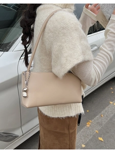 Beige leather baguette shoulder bag with silver chain and metal charm detail